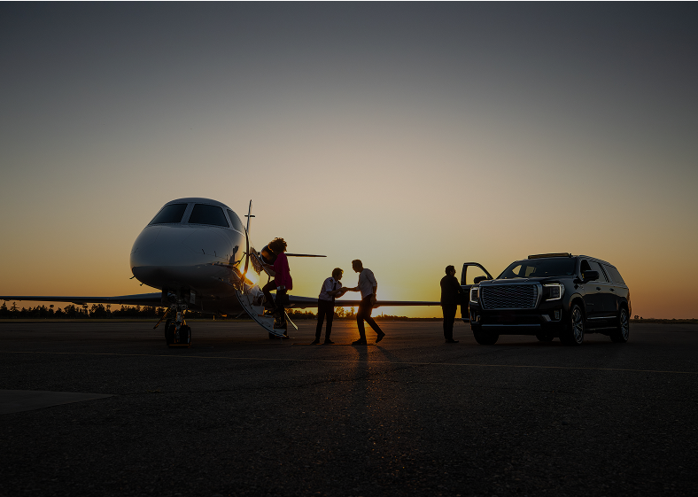 Private jet boarding at sunset with SUV.