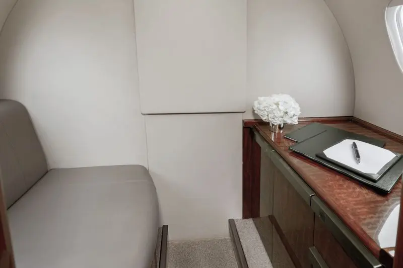 Compact seating and wooden desk in a small room corner.