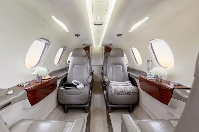 Luxurious private jet interior with spacious leather seats.