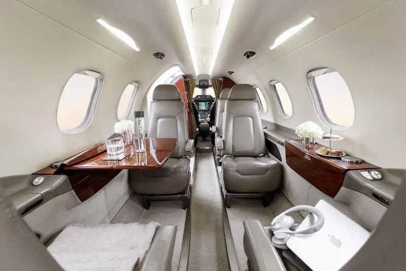 Luxurious interior of a private jet with plush leather seats and wooden accents.