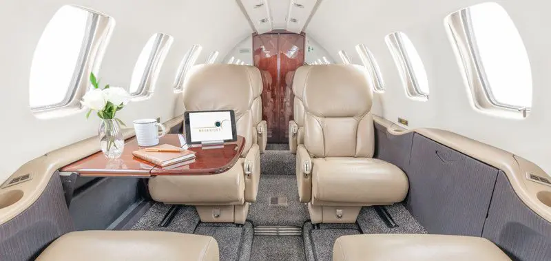 Luxurious beige leather seats inside a private jet cabin.