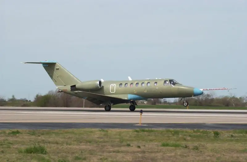 Private jet airplane taxiing on runway at airport.