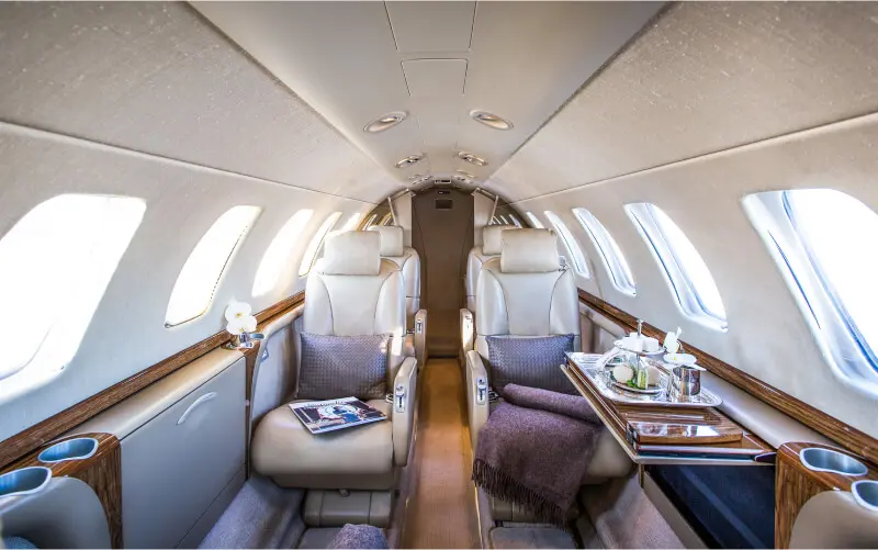 Luxurious private jet interior with plush leather seats and elegant décor.