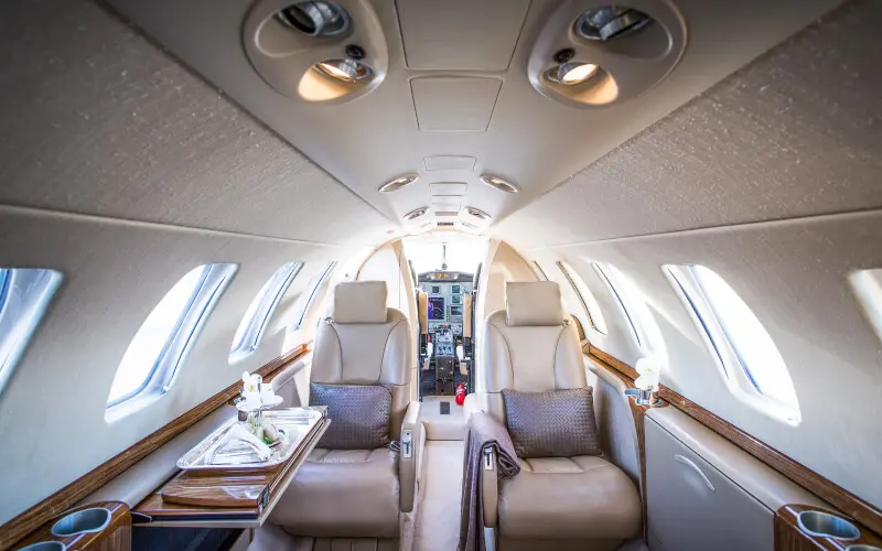 Luxurious interior of a private jet with comfortable leather seats.