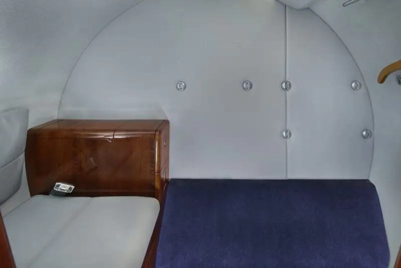 Cozy cabin interior with a wooden headboard and blue blanket.