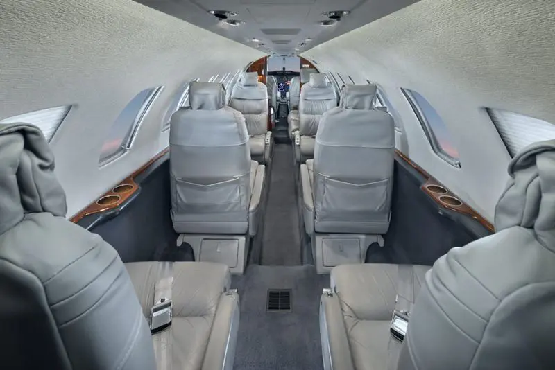 Luxurious private jet interior with comfortable leather seats.