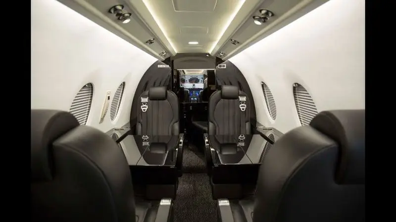 Luxurious private jet interior with spacious leather seats.
