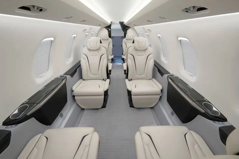 Luxurious beige leather seats inside a private jet cabin.