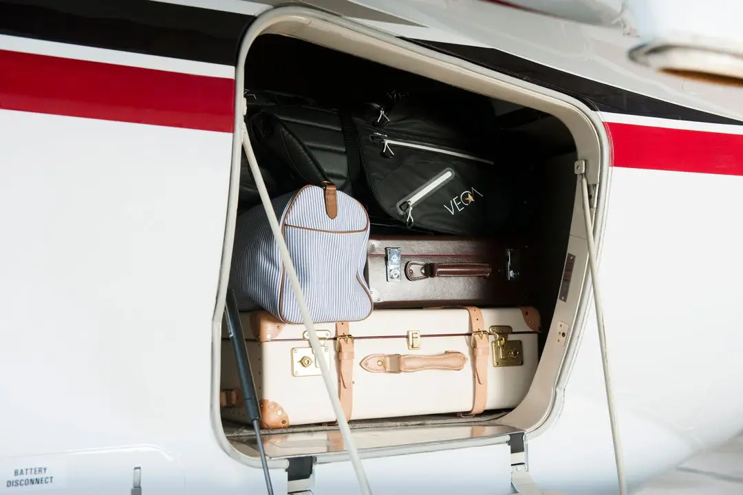 Suitcases and a bag packed in an airplane luggage compartment.