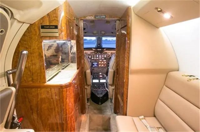 Luxurious yacht interior with cockpit and wooden finishes.