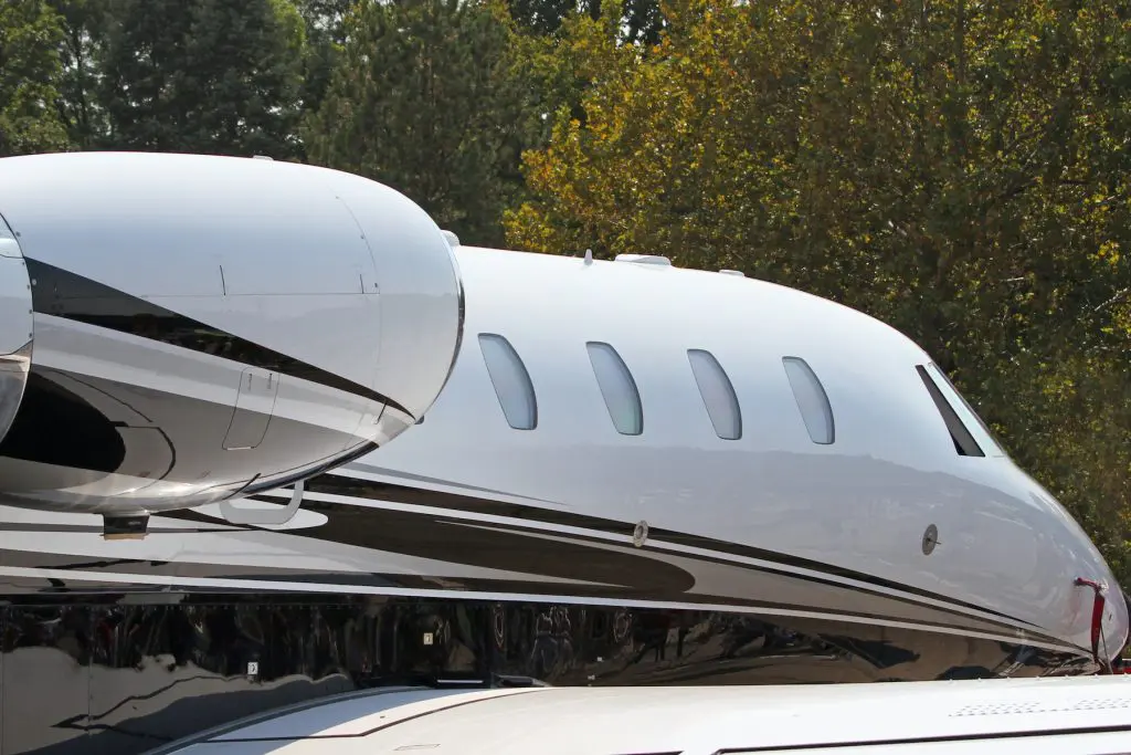 Close-up of a private jet with windows and wing visible.