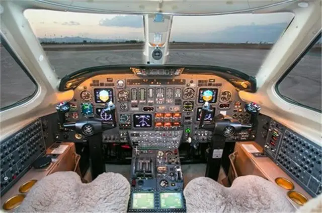Cockpit view of a small aircraft with detailed control panels and pilot seats.