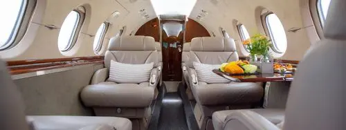 Luxurious interior of a private jet with comfortable leather seats.