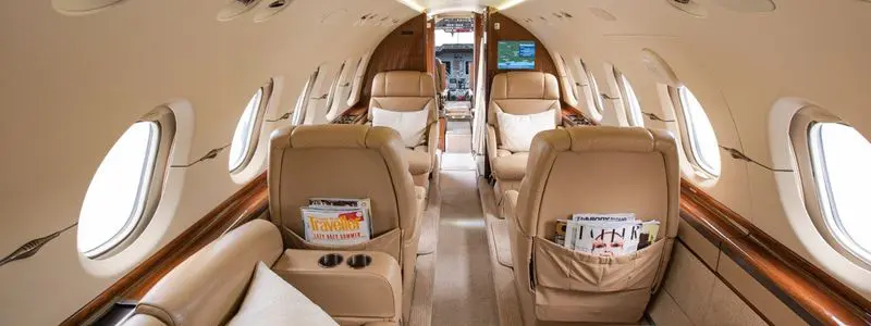 Luxurious private jet interior with beige leather seats.