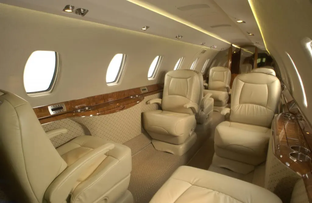Luxurious beige leather seats inside a private jet cabin.