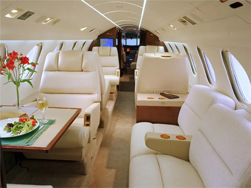 Luxurious private jet interior with plush white leather seats.