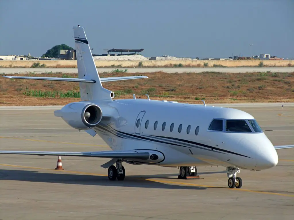 Private jet taxiing on the runway at an airport.