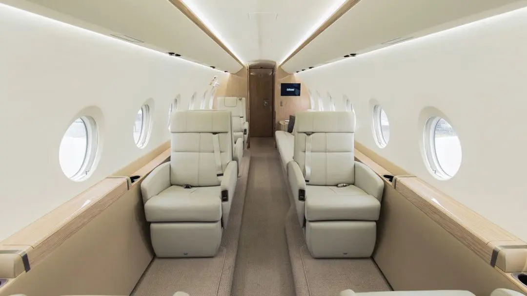 Luxurious private jet interior with plush leather seats and elegant lighting.