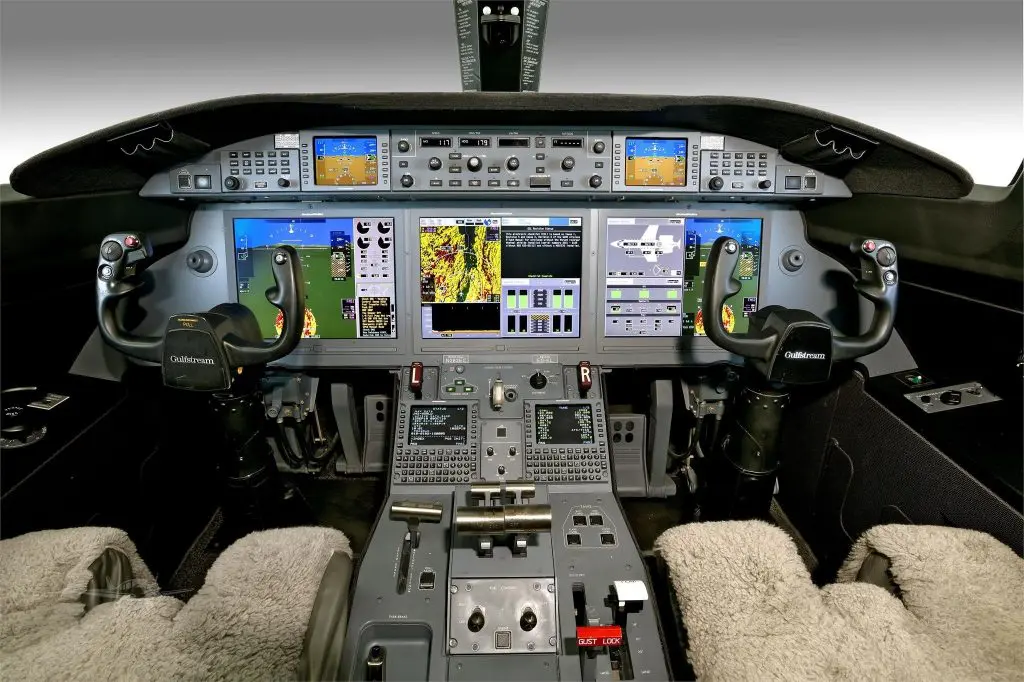 Modern aircraft cockpit with multiple digital displays and controls.