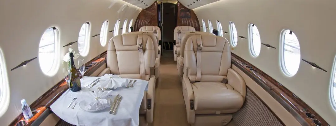 Luxurious beige leather seats inside a private jet cabin.