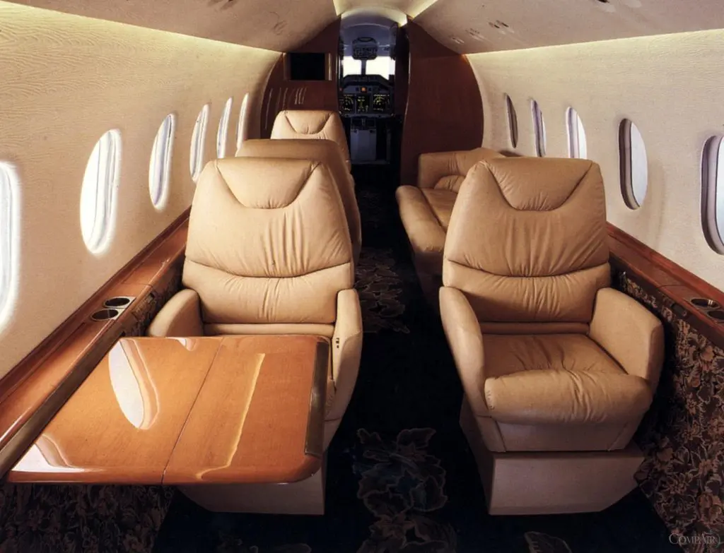 Luxurious beige leather seats inside a private jet cabin.