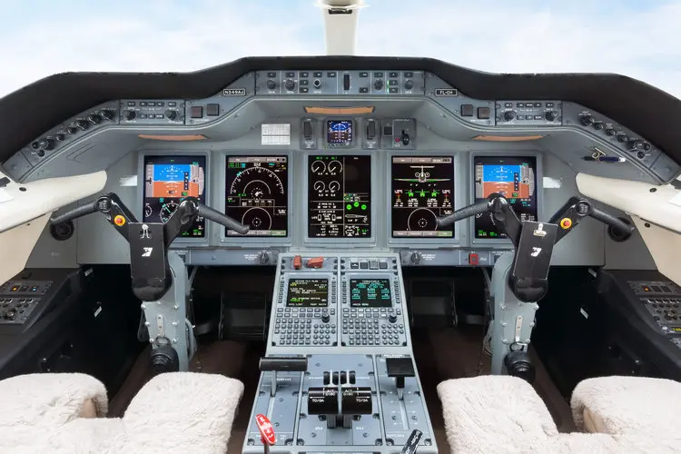 Modern airplane cockpit with digital controls and displays.