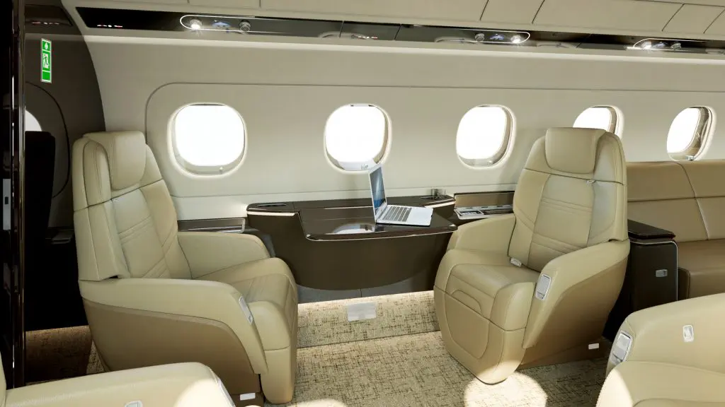 Luxurious private jet interior with plush leather seats and a sleek desk.