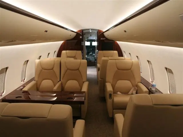 Luxurious beige leather seats inside a private jet cabin.