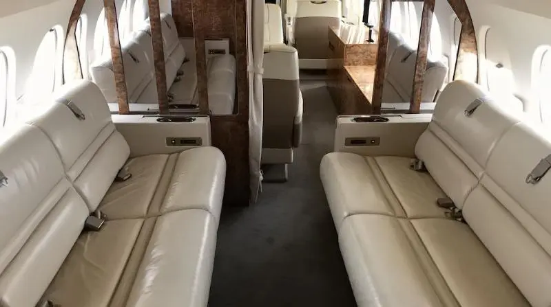 Interior of a compact camper van with seating and sleeping areas.