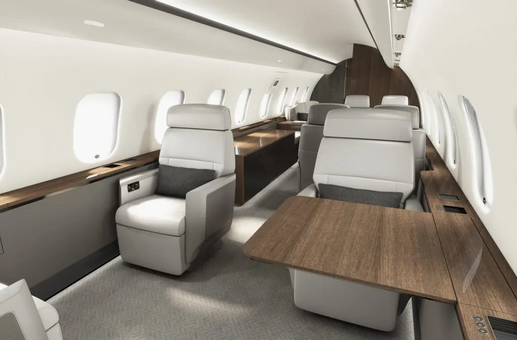 Luxurious private jet interior with spacious leather seats and wooden tables.