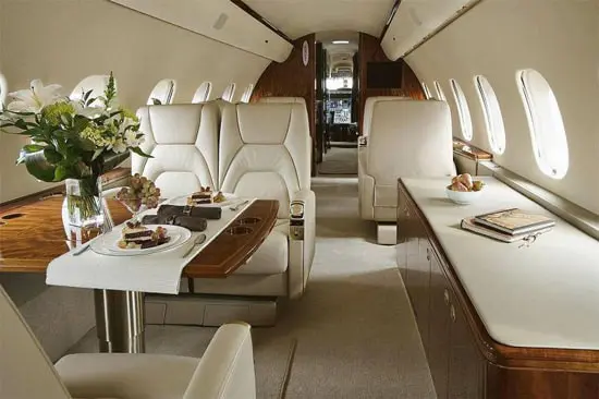 Luxurious private jet interior with plush leather seats and elegant wood accents.