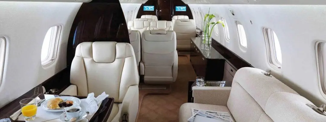 Luxurious interior of a private jet with plush leather seats and elegant decor.
