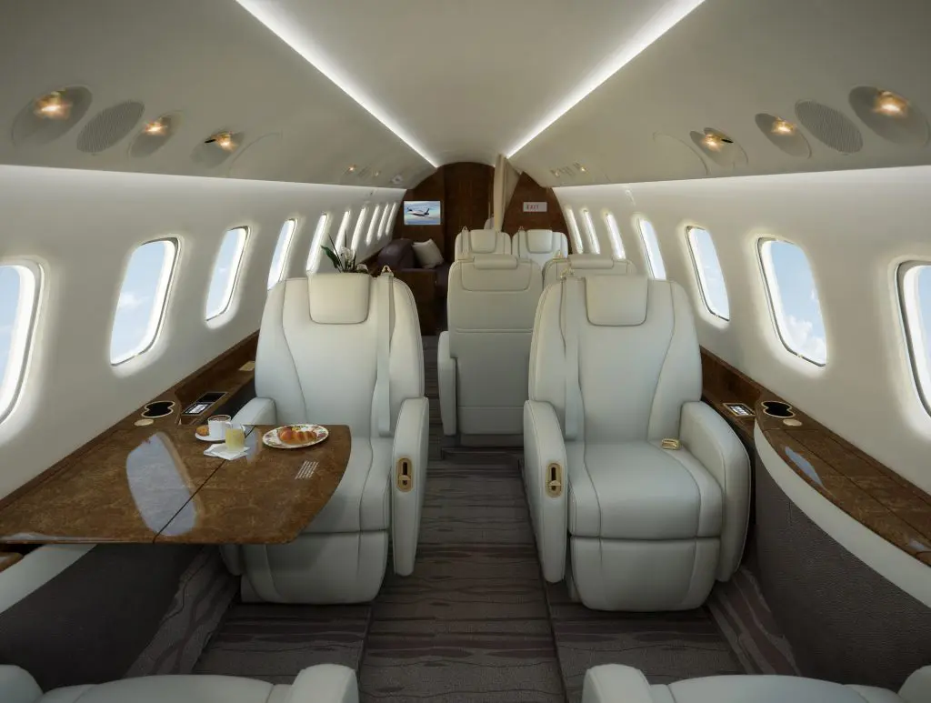 Luxurious private jet interior with spacious leather seats and wooden accents.