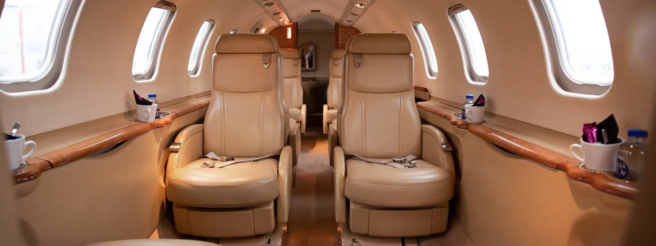 Luxurious tan leather seats inside a private jet cabin.