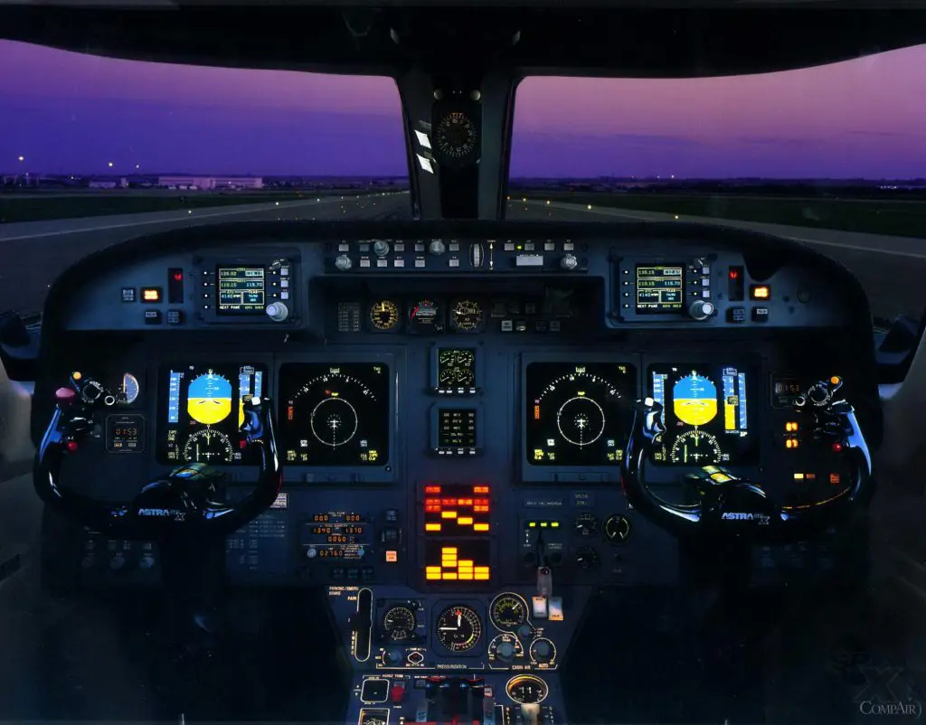 Cockpit of an airplane illuminated during twilight.