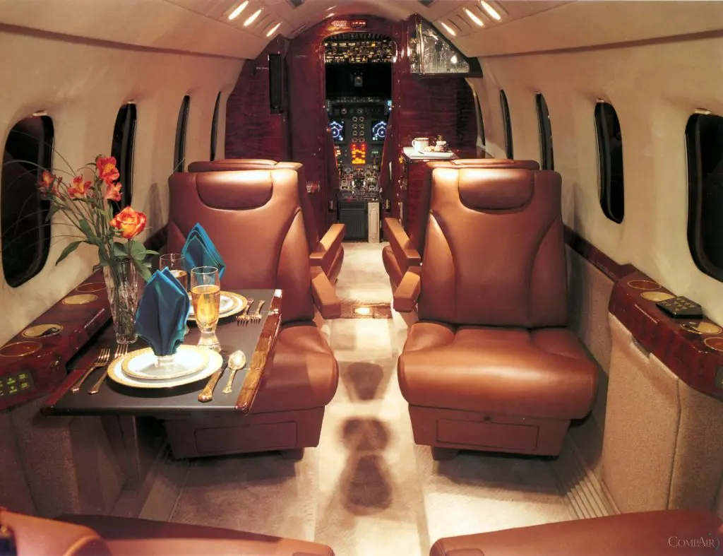 Luxurious seats and elegant dining setup inside a private jet cabin.