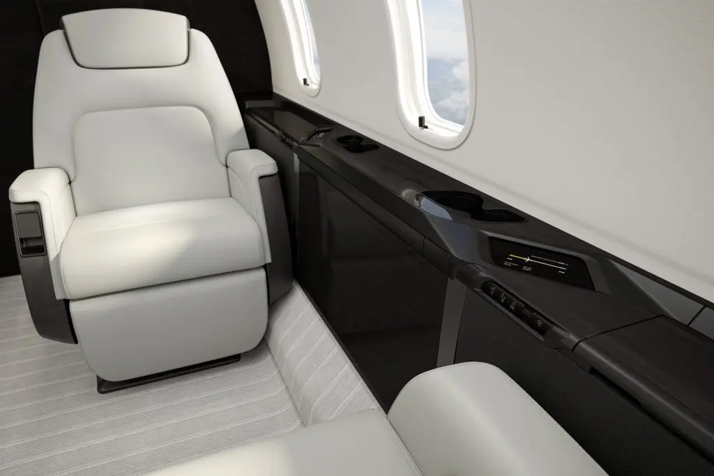 Luxurious leather seats inside a private jet with a large window.