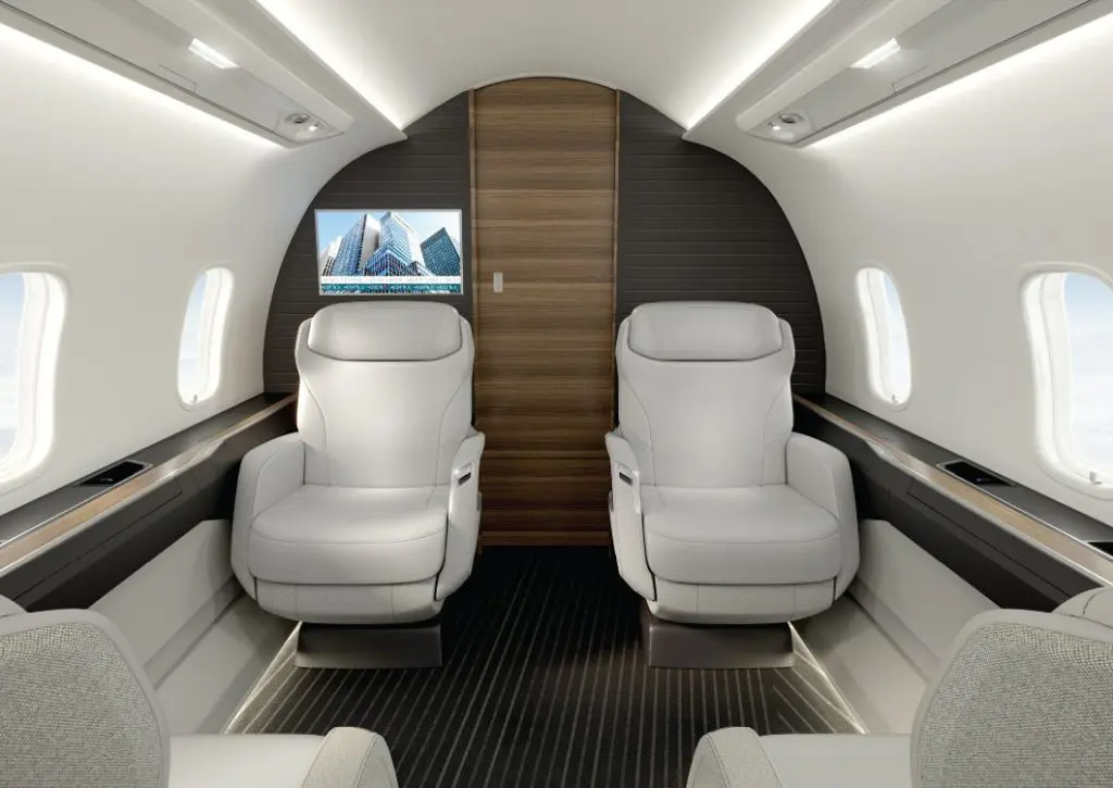 Luxurious private jet cabin with two white leather seats.