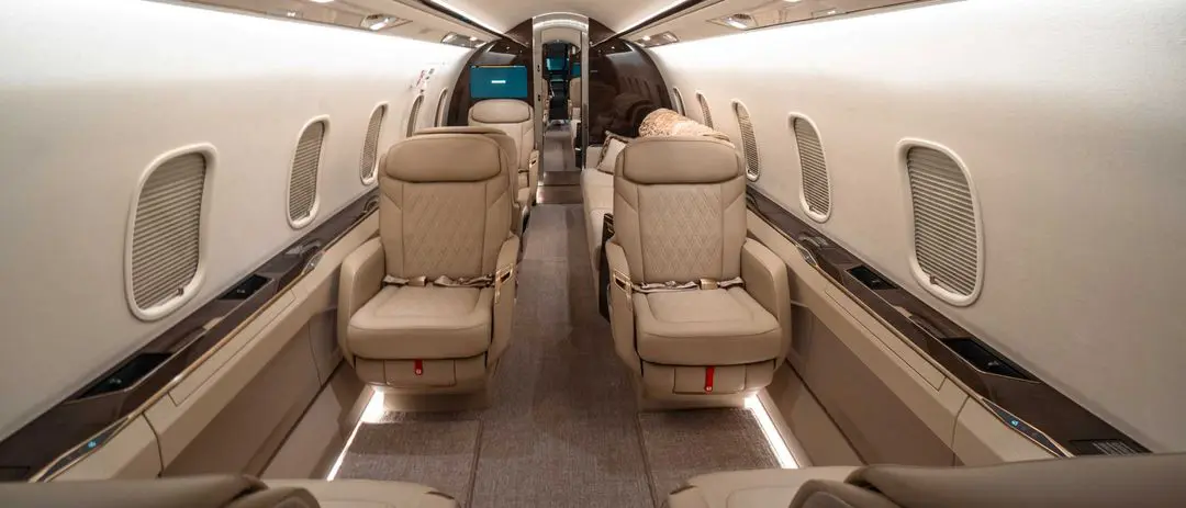 Luxurious beige leather seats inside a private jet cabin.
