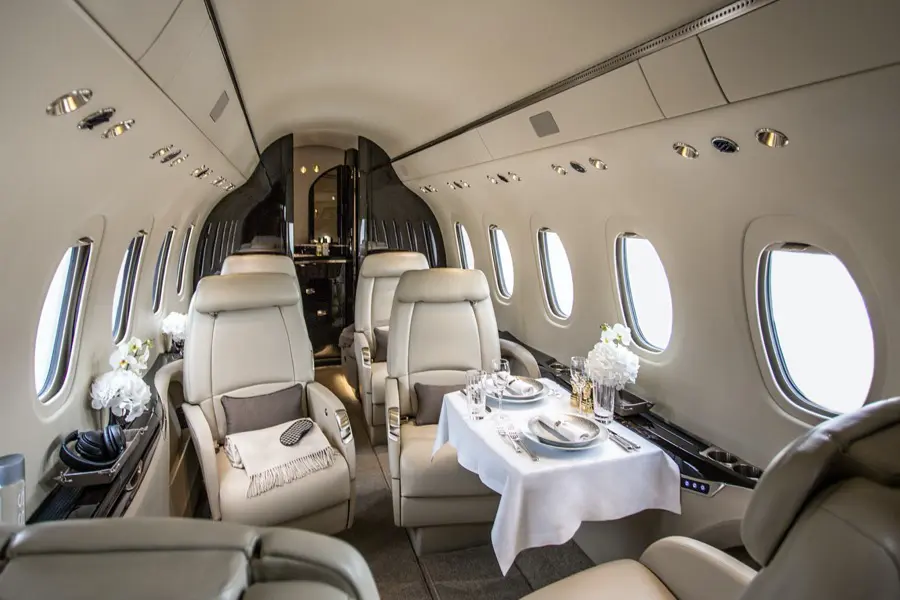 Luxurious private jet interior with elegant seating and dining setup.