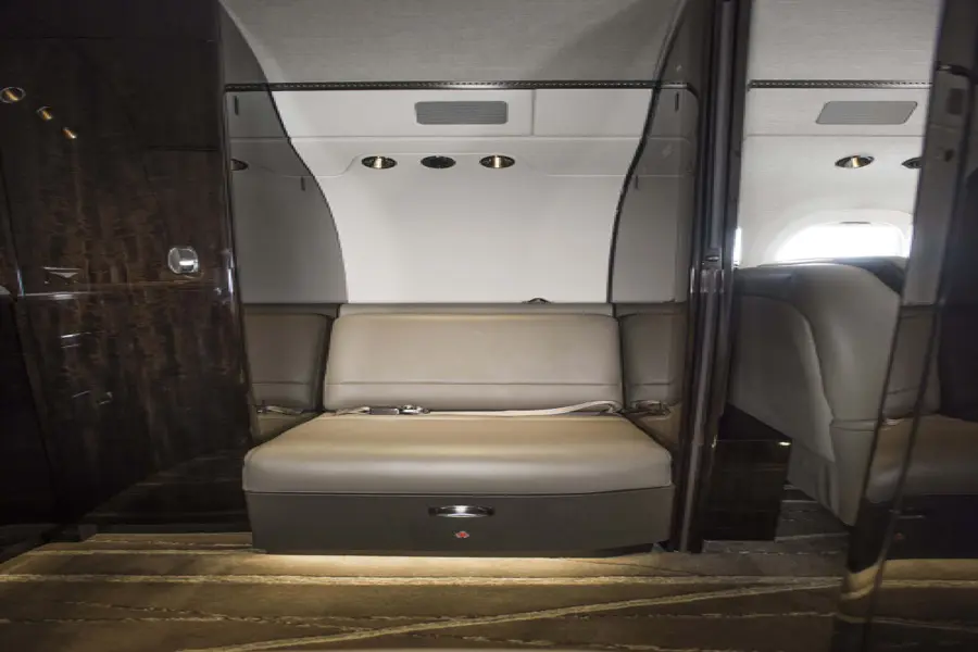 Luxurious beige leather seating with modern overhead lighting in a sleek interior.