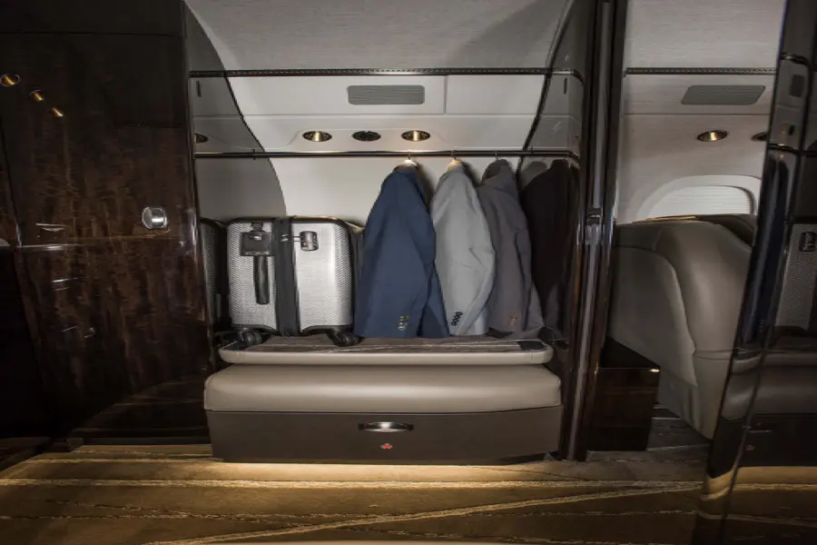 Luggage neatly stored in a private jet's compartment.