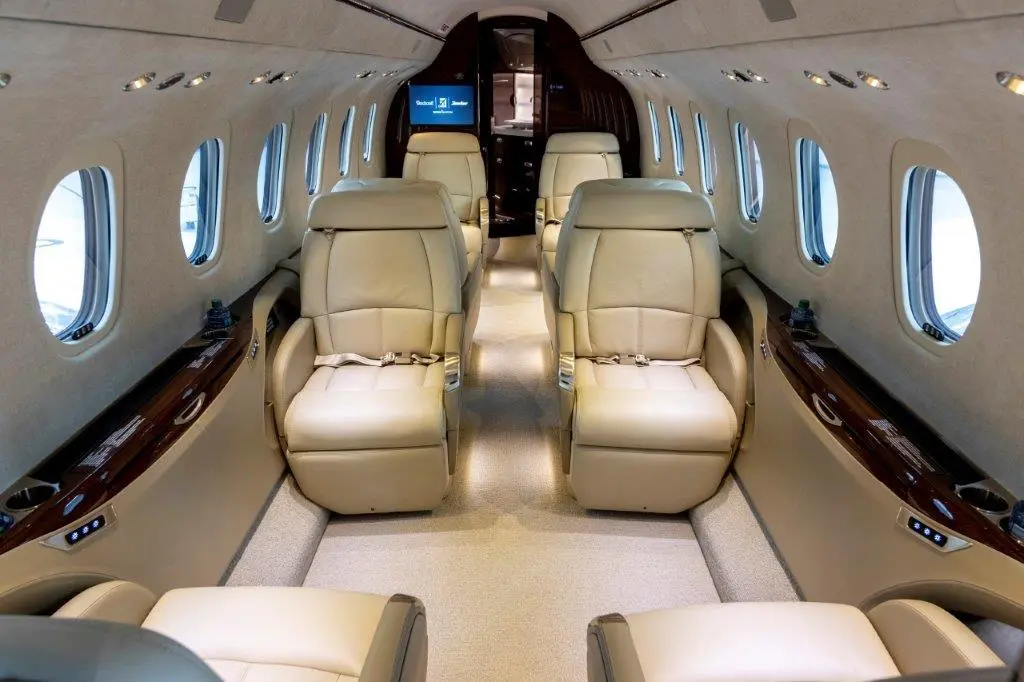 Luxurious beige leather seats inside a private jet cabin.