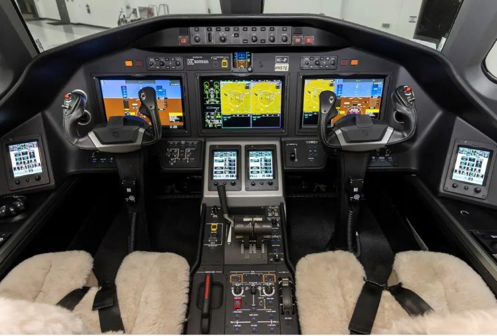 Modern aircraft cockpit with multiple digital displays and controls.