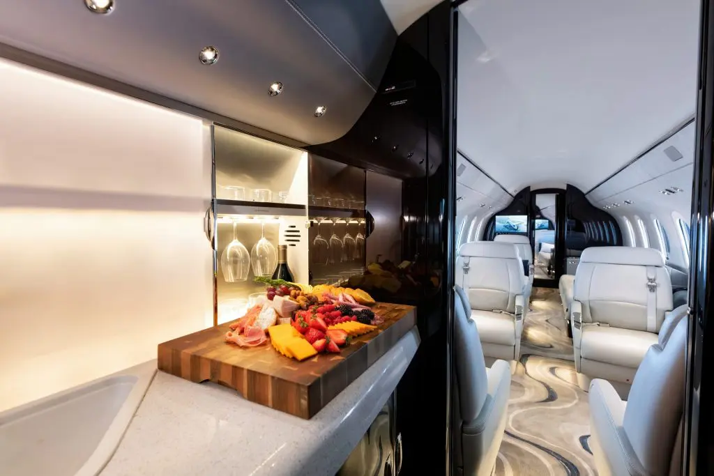 Luxurious yacht kitchen with fresh fruit on a wooden cutting board.