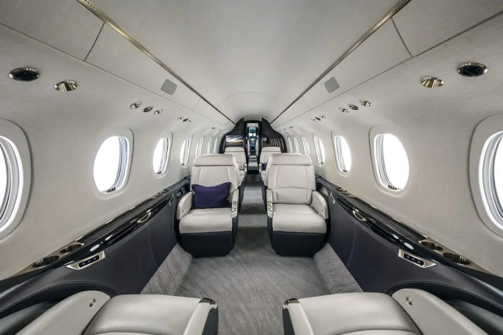 Luxurious private jet interior with plush leather seats and elegant design.