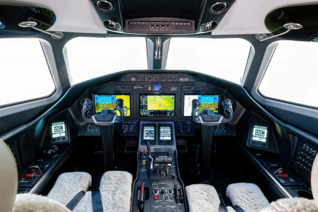 Modern aircraft cockpit with digital displays and controls.