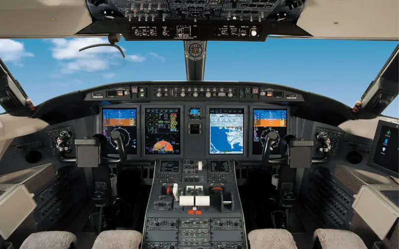 Modern airplane cockpit with digital flight displays and controls.