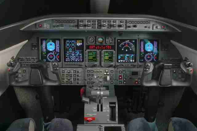 Cockpit of an aircraft with digital displays and control panels.