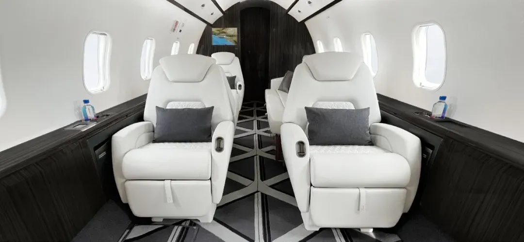Luxurious white leather seats inside a private jet cabin.